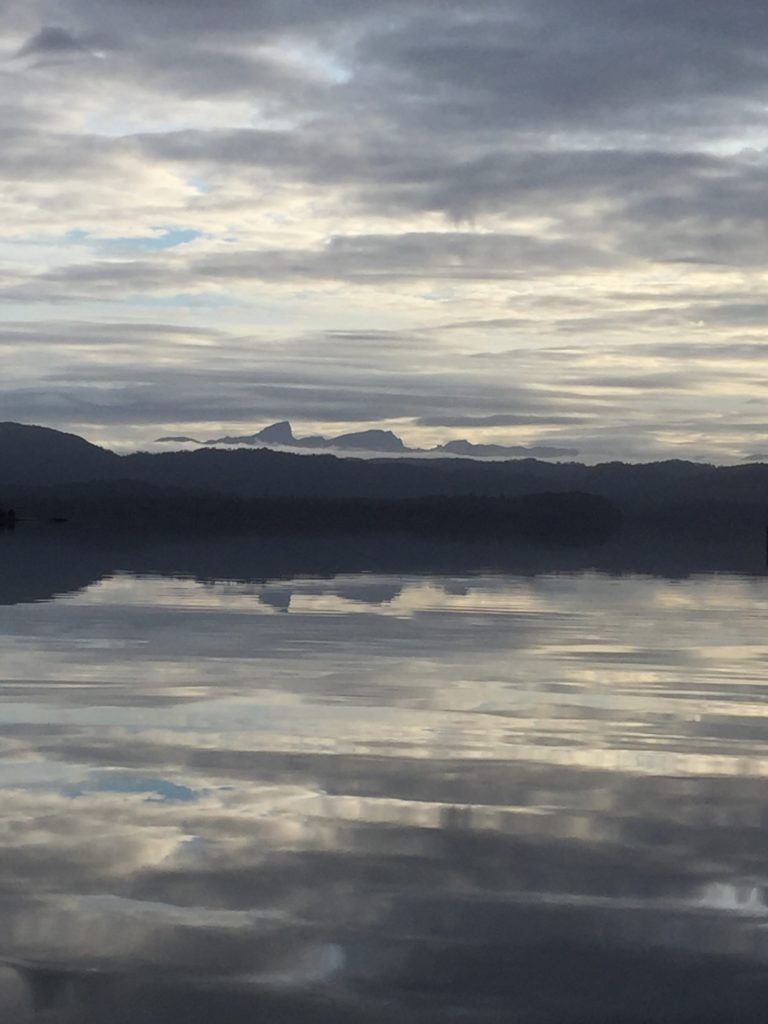 Mountain Silhouette near water front and clouds